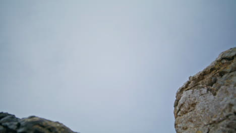 active woman running nature stones at cloudy sky bottom view. dynamic runner