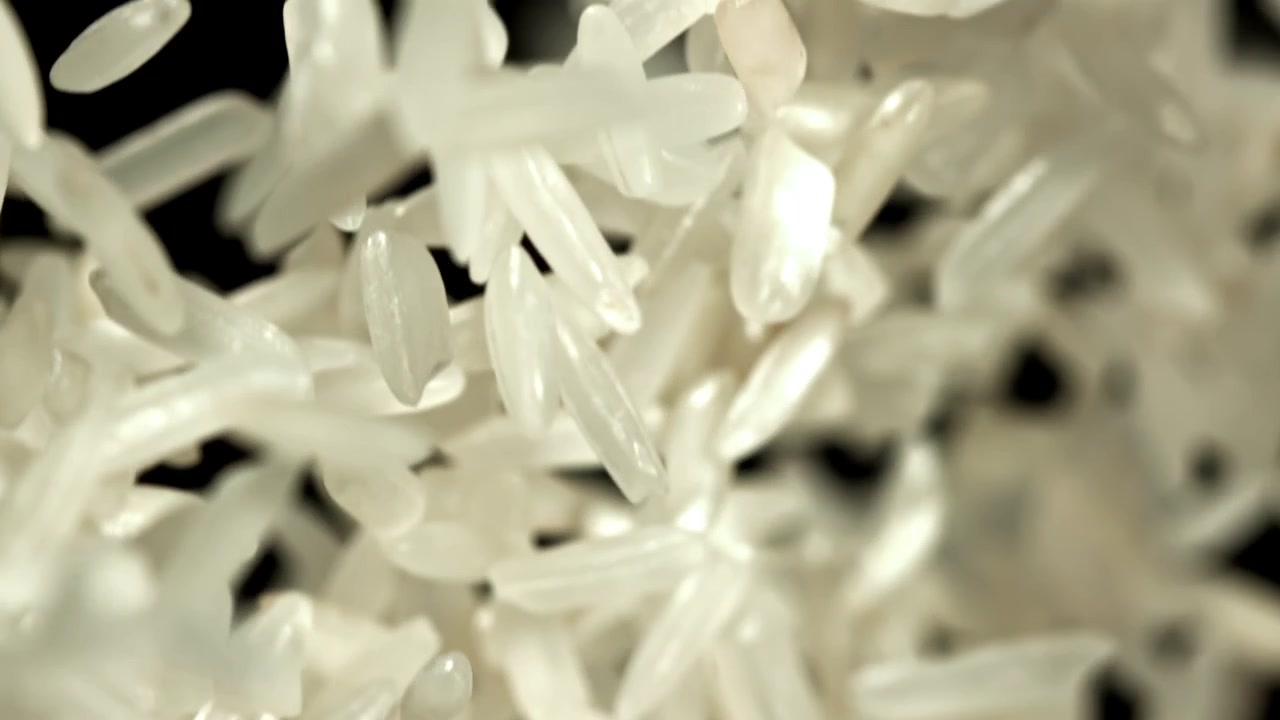 Grãos de Arroz Branco Caindo em Câmera Lenta em Fundo Preto