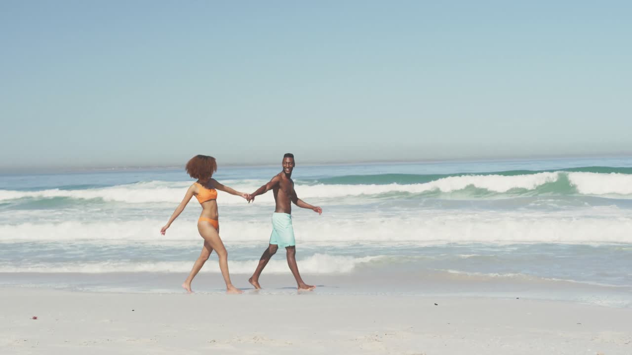 African American couple walking seaside