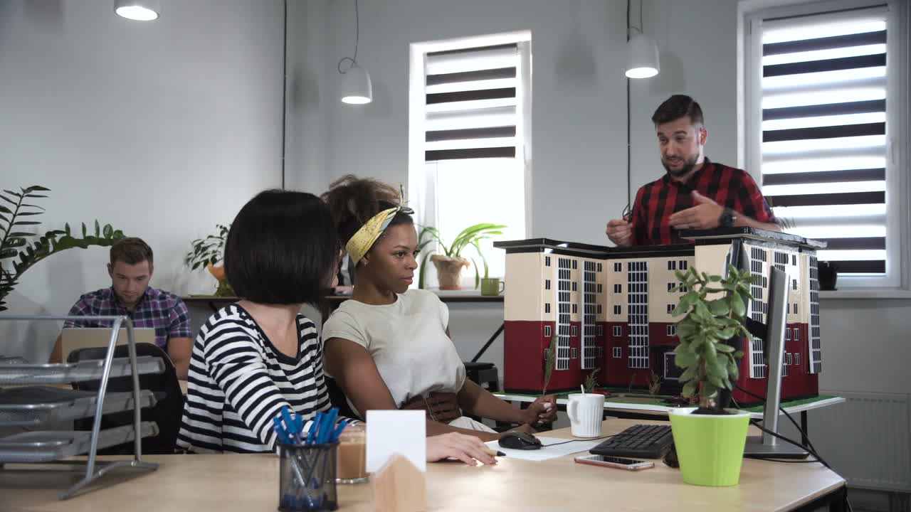 Architects discussing a building model in a modern office