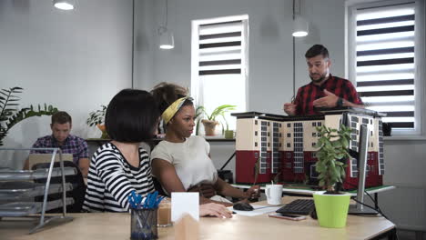 architects discussing a building model in a modern office