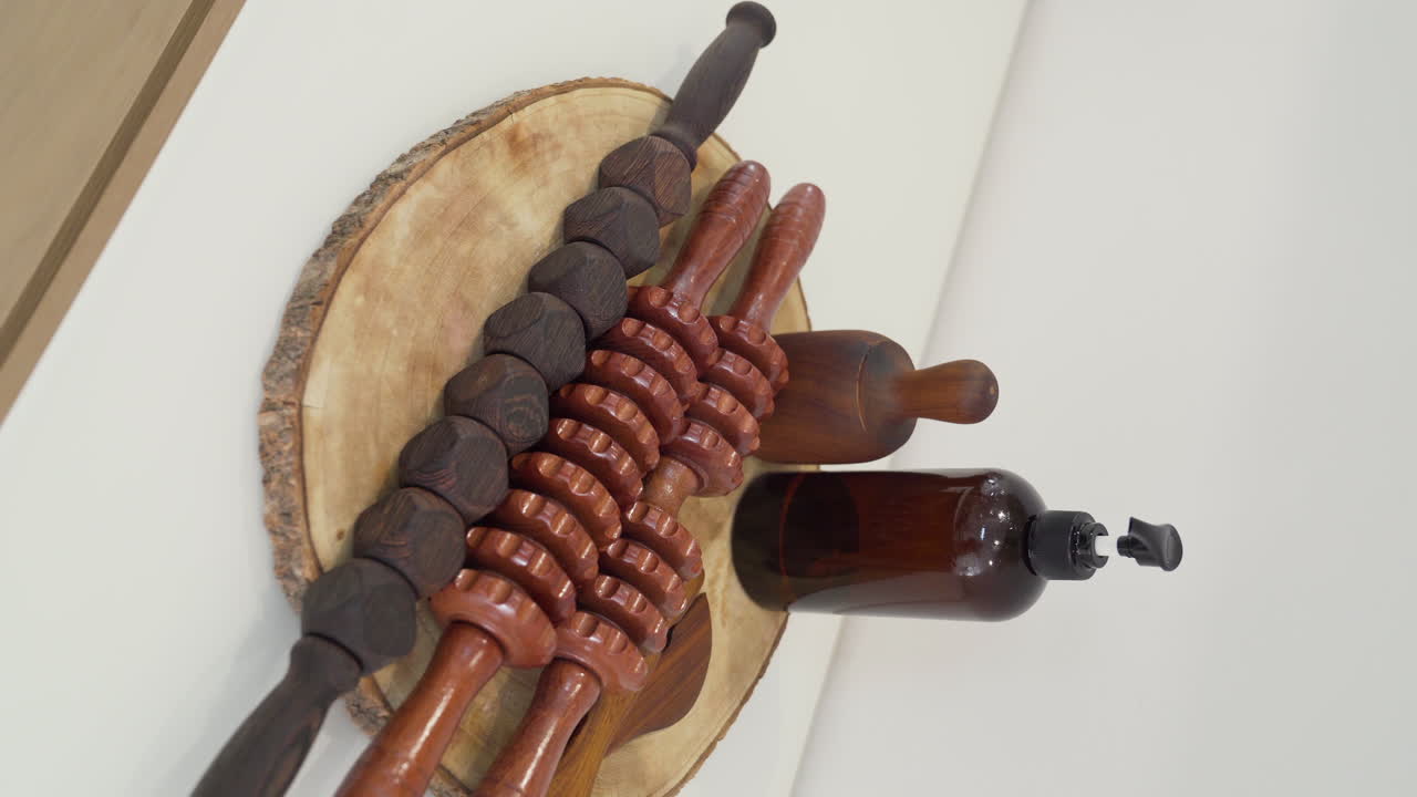 Set of wooden tools with different types of rollers, cup, paddles and oil for wood therapy
