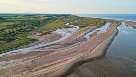 descubra el encanto idílico de una escena costera de la hora de oro a través de impresionantes imágenes aéreas de drones: estuario, bancos de arena, océano y pantanos