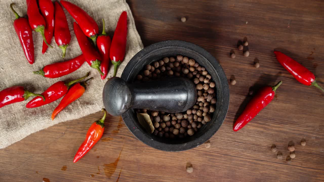 los guisantes de pimienta negra en un mortero giran lentamente.