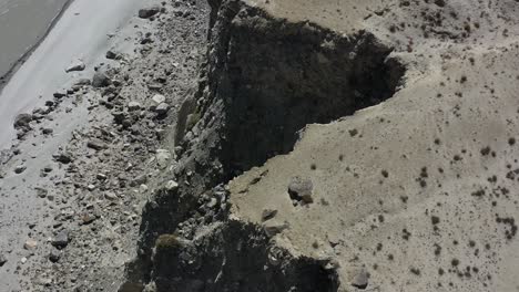 drone aéreo volando sobre un acantilado de montaña empinado con vistas a una caída en las rocas de abajo