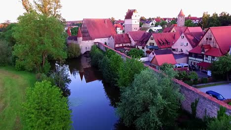 a drone flies over the river along the wall of the old town and the park aerial view