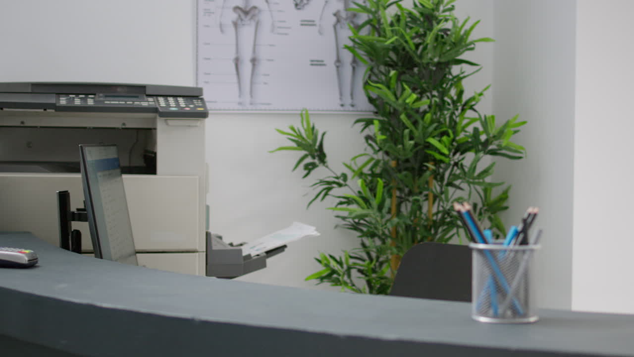 Medical office reception desk with printer and plant