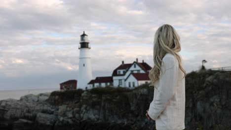 beautiful blonde woman looking out to lighthouse