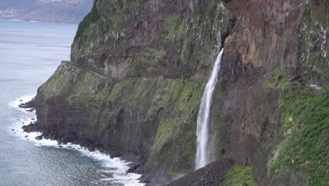 awesome big waterfall falling from a cliff into the ocean