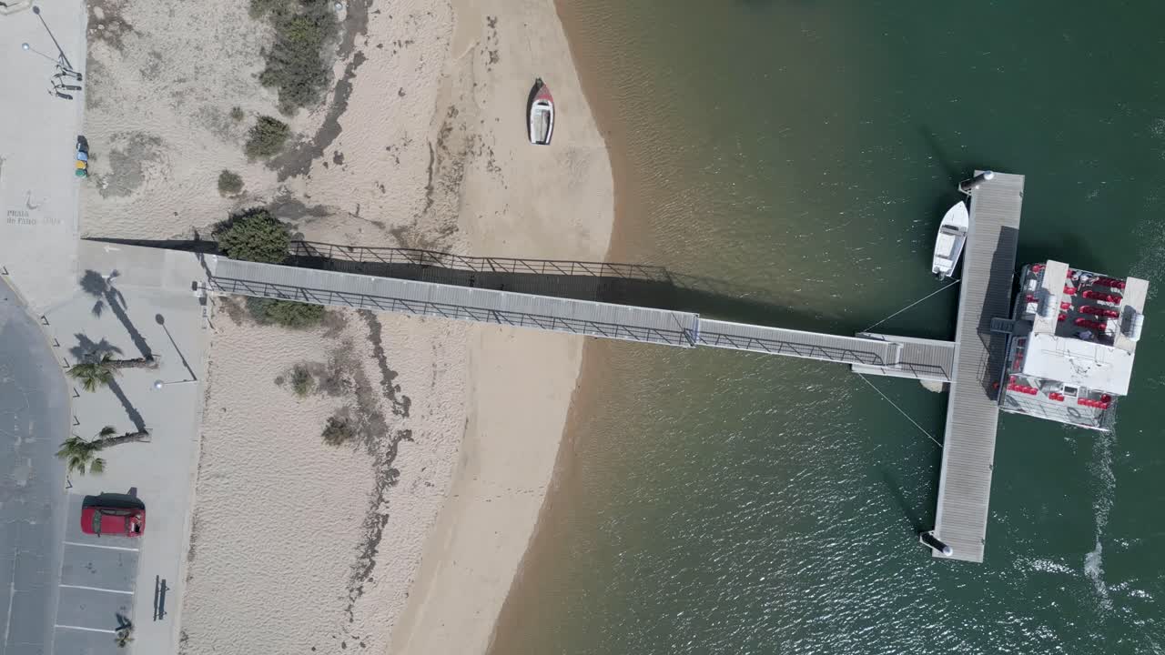 공중 사진 은 관광객 들 이 착륙 한 후 에 비어 있는 페리 를 포착 하고 있으며, 부드러운 파도 가  ⁇ 빛 에 반 ⁇ 여 평화로운 해양 그림 을 그린다