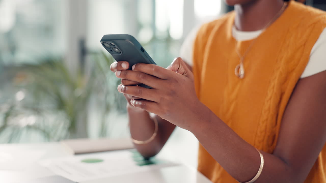 Close-up of Person's Hands Scrolling on a Smartphone at a Desk