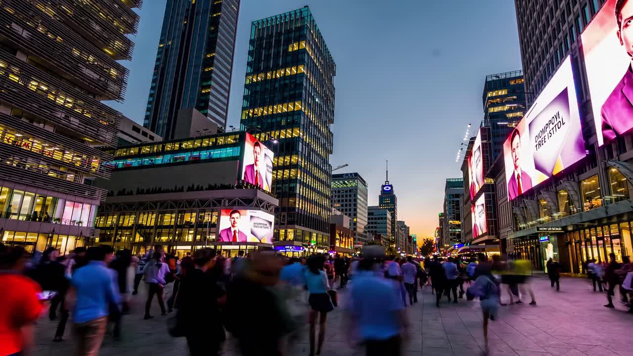 A lively city street teeming with pedestrians relishing the evening atmosphere amid a colorful and dynamic urban landscape