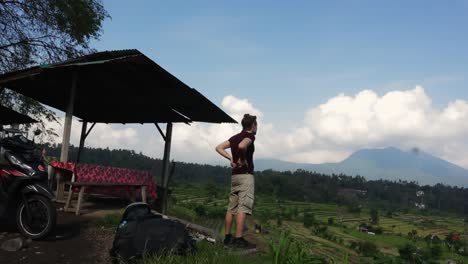 caucasian guy looking over beautiful rice terrace landscape, day time