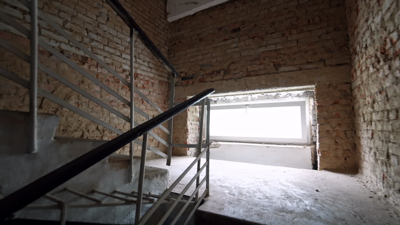 Going up by the stairs in the old building. Walk along the bare brick walls in the renovated house.