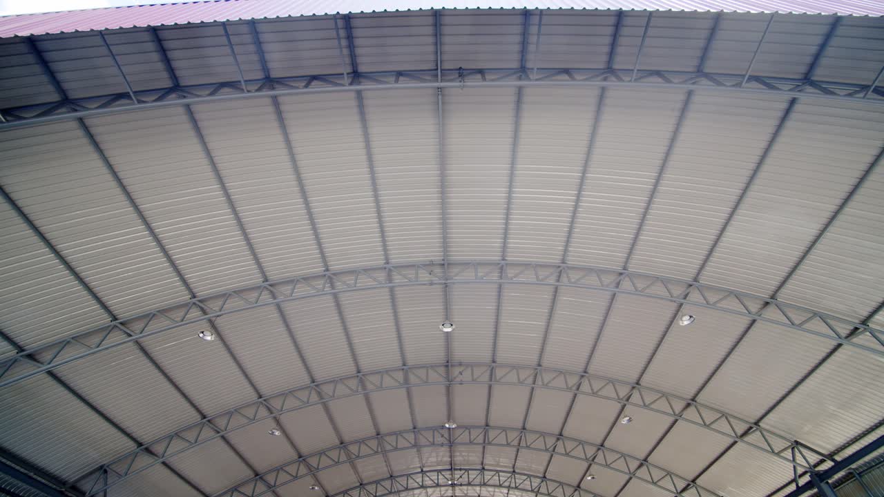 un techo protector cubre un enorme estacionamiento - vista inclinada hacia arriba del interior de la estructura y las vigas