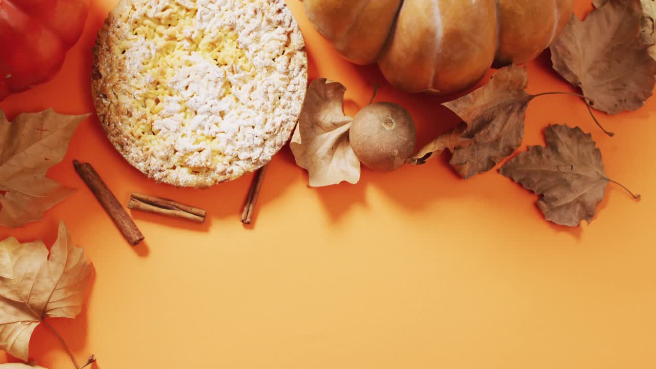 Video di foglie autunnali, zucca, spezie e torta su sfondo arancione