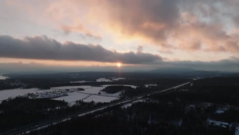 sunlight streaming through clouds during sunrise over winter landscape