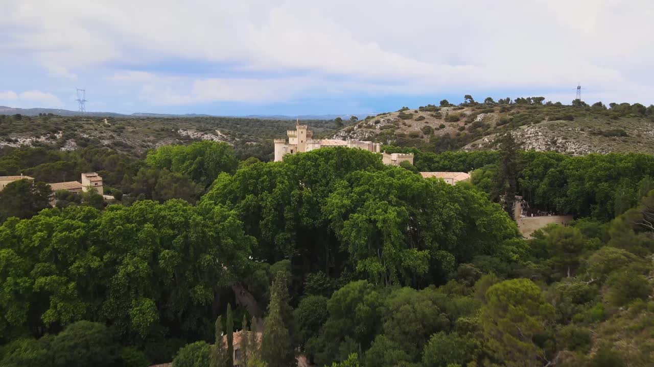 Chateau Comtal Provence France, nestled behind lush green trees, bird's eye view aerial