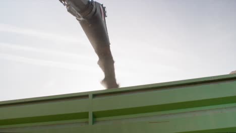 Unloading-harvested-organic-soy-into-trailer-from-combine-harvester-slow-motion