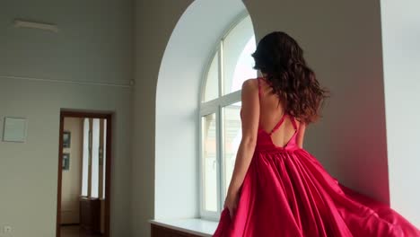 elegant woman in flowing red dress captured in stunning interior, showcasing motion and graceful beauty, perfect for fashion and artistic inspiration