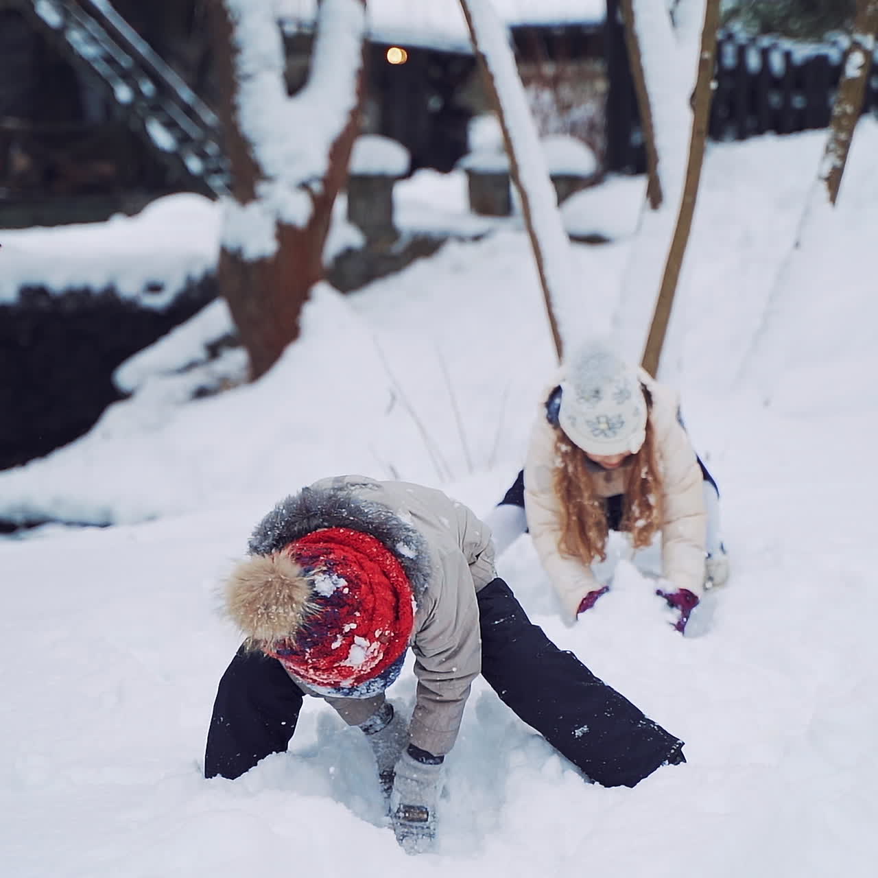 Cheerful children are throwing soft snow on the background of winter river. Little kids are playing happily with white snow in winter in the forest. Slow motion.