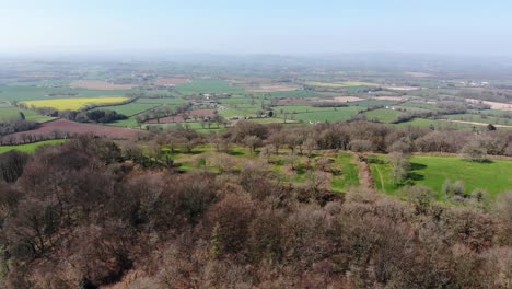 Aerial-panning-right-shot-of-the-Iron-age-Hill-Fort-at-Hembury-Devon-England-with-the-East-Devon-Countryside-in-the-background