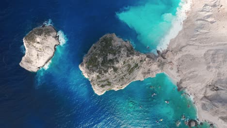 vista aérea de una playa aislada y rocas en el agua azul del mar