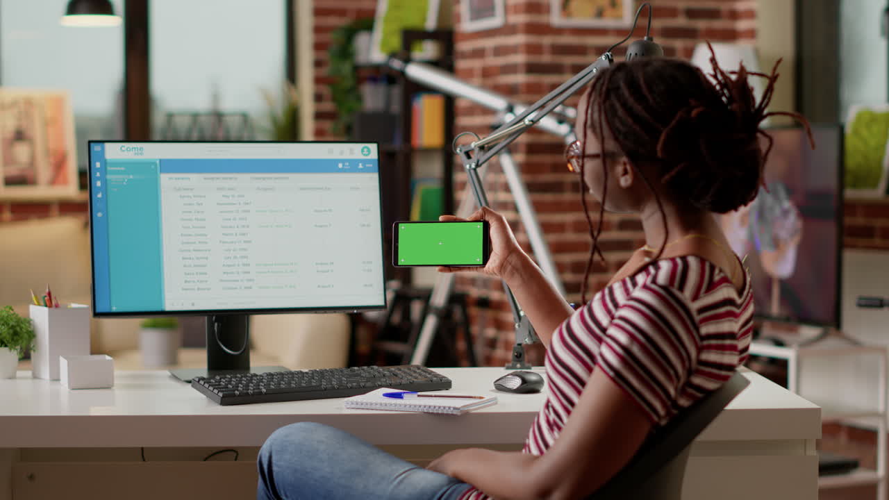 Woman in office with computer and phone