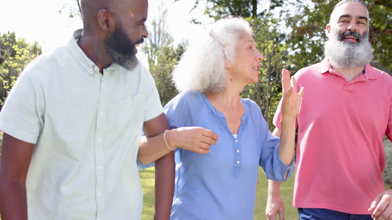 Walking outdoors, senior friends talking and enjoying time together in park