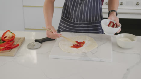 Asian-male-teenager-preparing-food-and-wearing-apron-in-kitchen