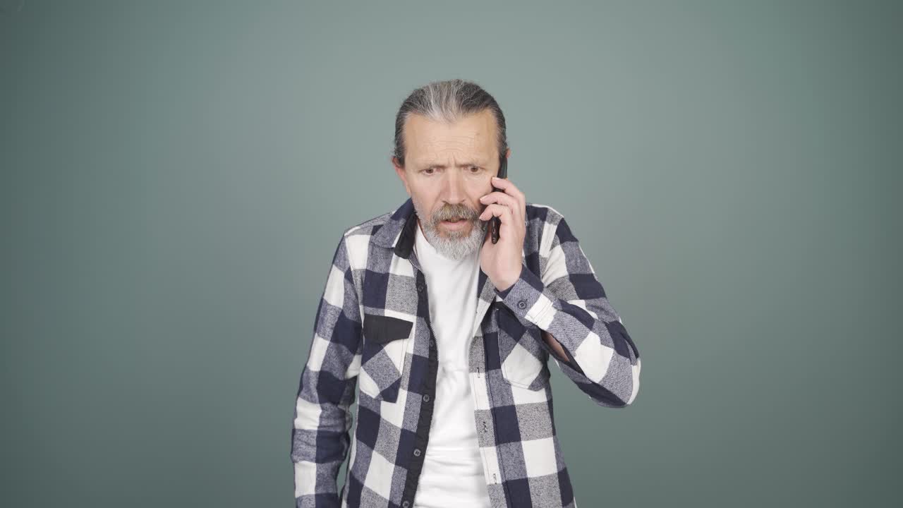 화난 남자가 전화로 얘기하고 있어요.