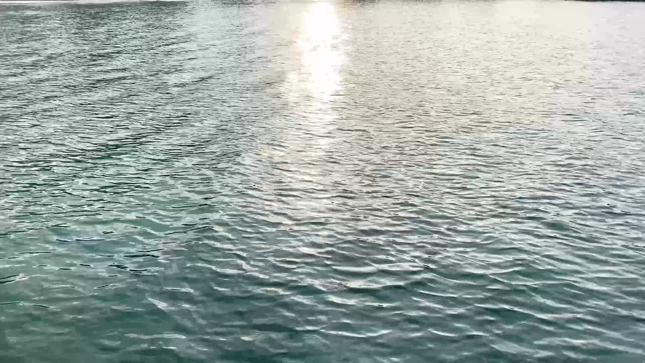 부드러운 물 표면 배경 영상, b-roll 영화, 물 속의 파란 하늘과 구름의 반사, 바다의 파도에서 빛나는 빛, 아름다운 자연 스크린 배경.