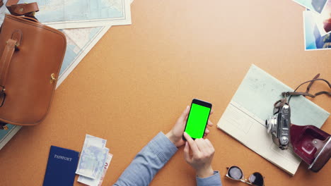 top view woman traveler hands planning holiday using mobile phone app vintage desk from above - red epic dragon