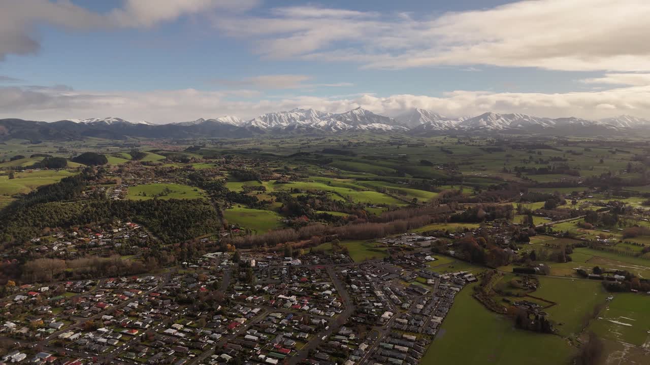 From high above, this bird's-eye view captures the entire layout of Geraldine town, its relationship to the countryside, and the majestic mountain range on the horizon