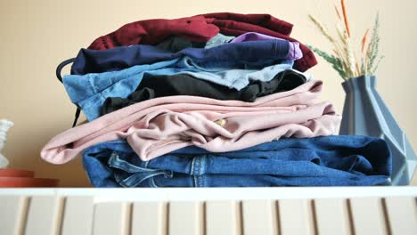 a stack of folded clothes on a dresser