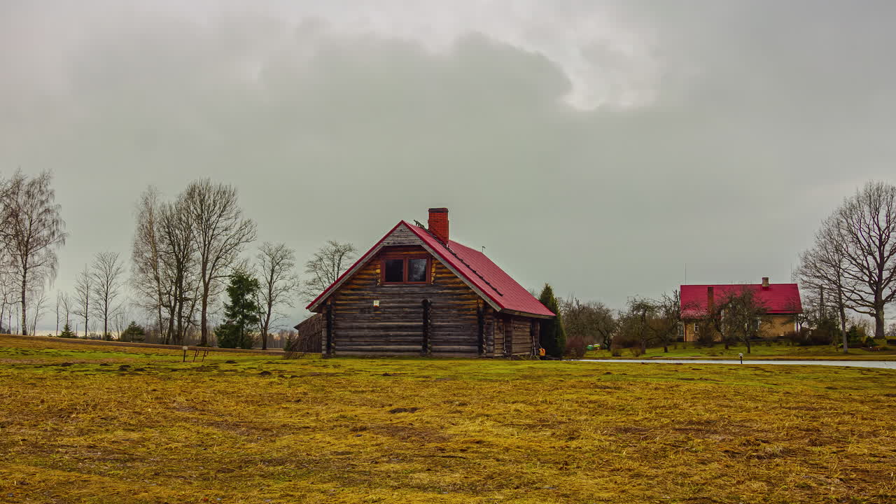 las nubes ruedan por encima de la cabaña de madera estilo casa en el campo, timelapse