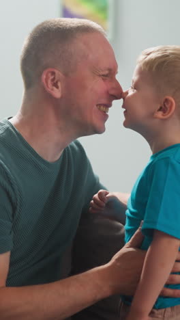 man plays with child, dad and son rub their noses, laugh, joi, kiss, happy