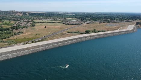 drone aerial from a high perspective of a boat near a levee and city