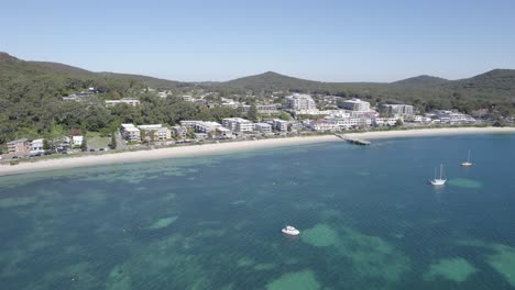 Aerial-View-Of-Beachfront-Hotels-Facing-The-Calm-Blue-Sea-In-Shoal-Bay,-Port-Stephens,-Australia