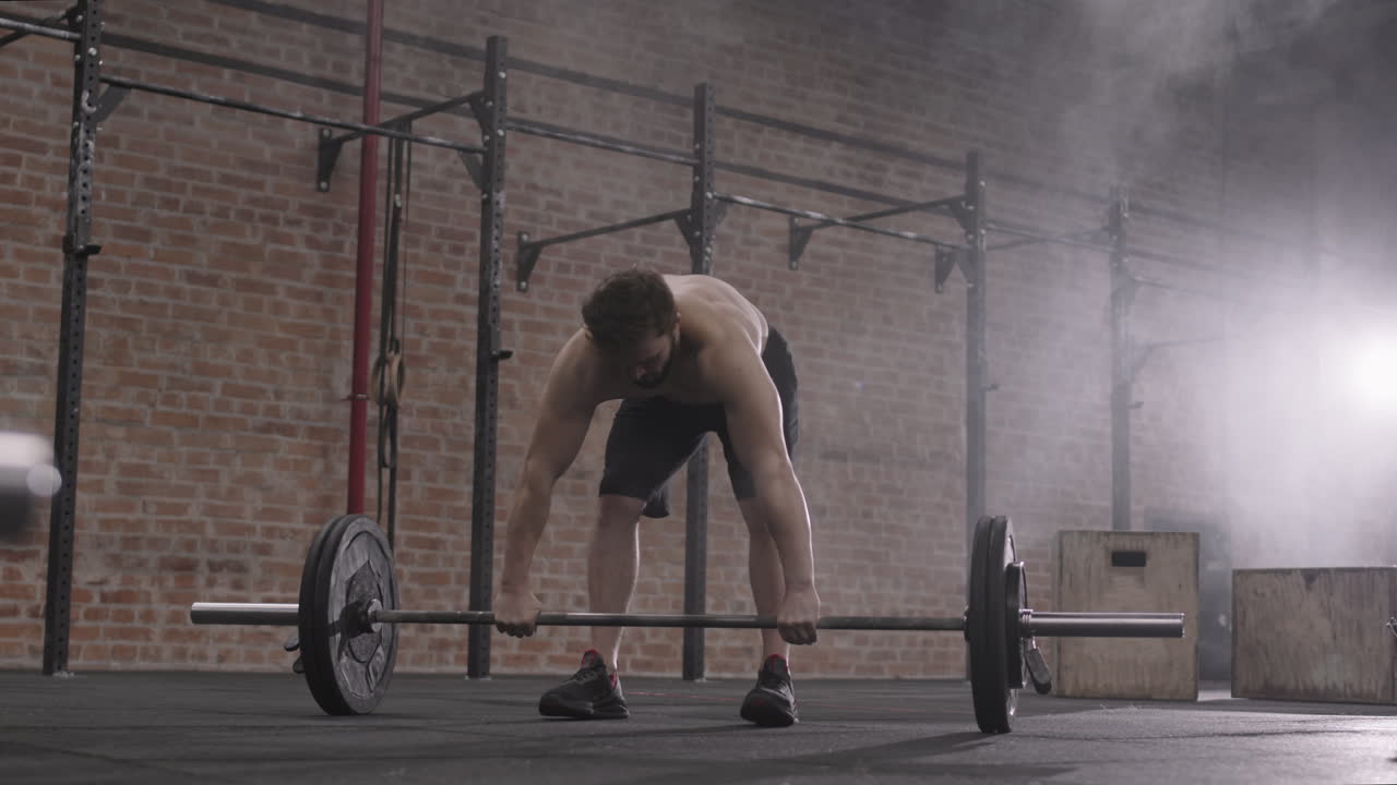 Muscular Sportsman Lifting Barbell during Intensive Training