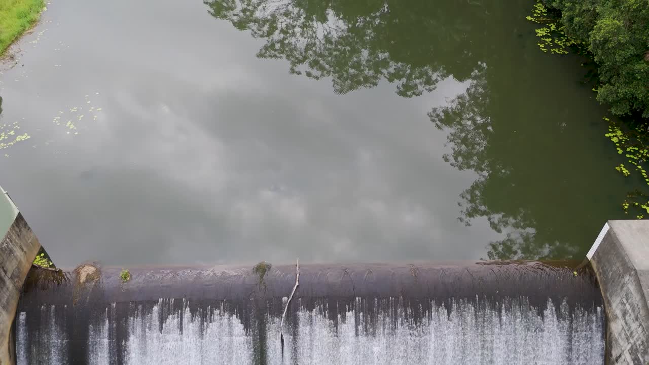 Aerial footage of Tullebudgera Dam and lush greenery in Gold Coast, Australia. Calm water and vibrant foliage create a serene atmosphere