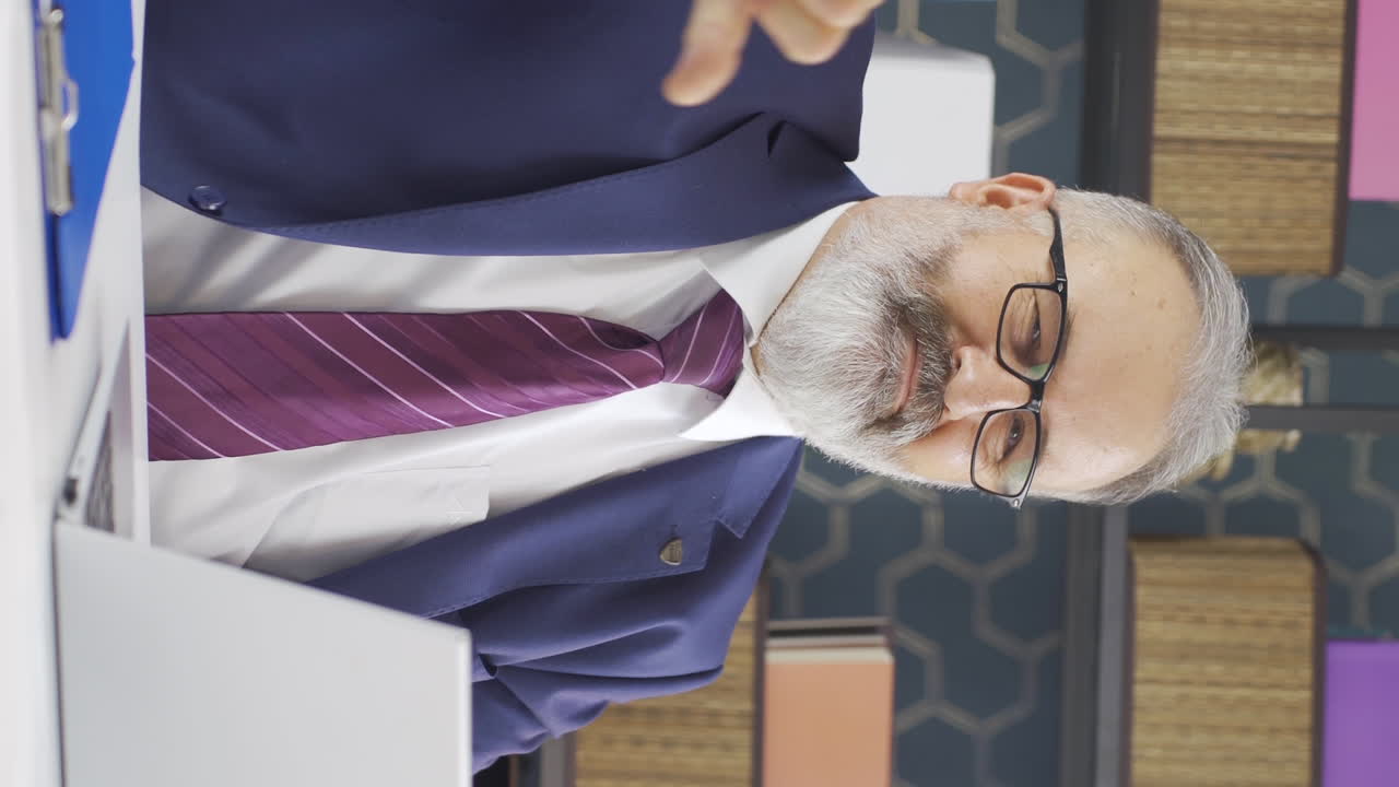 Lodret video af ældre forretningsmand, der kigger ind i kameraet med negativ gestus