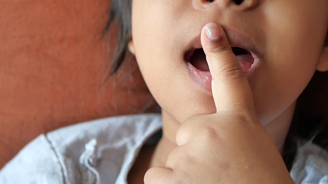 Bambino con il dito sulla bocca