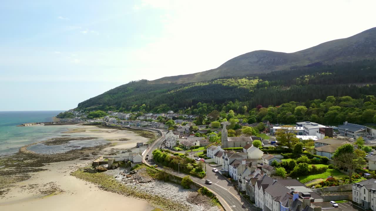 Aerial video of Newcastle Beach, The Mourne Mountains and Slieve Donard in Newcastle, County Down in Northern Ireland, UK on a bright and sunny day. Filmed in 4K, 60fps and with Rec709 Color.