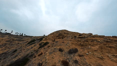 雲天在海邊的岩石斜坡上空飛向前方