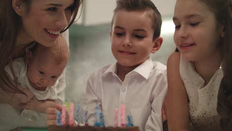 Alles-Gute-Zum-Familiengeburtstag-Zu-Hause.-Familie-Bläst-Kerzenflammen-Auf-Partykuchen