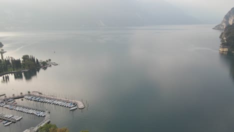 Aerial-View-of-Lake-Garda,-North-Italy,-Scenic-Coastline-and-Calm-Water-on-Sunny-Morning,-Drone-Shot