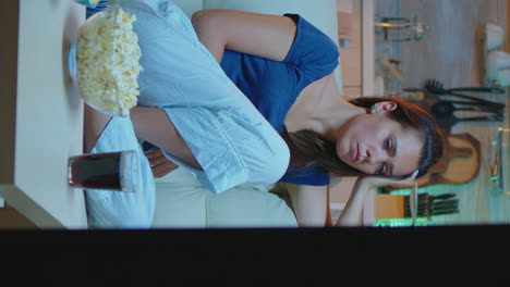 vertical video: woman falling asleep on sofa