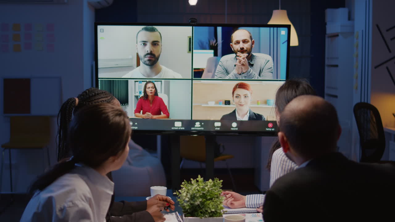 Multi ethnic businesspeople discussing company statistics with remote coworkers