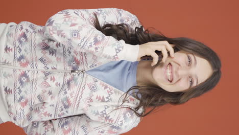 Vertical-video-of-Happy-talking-young-woman-on-the-phone.